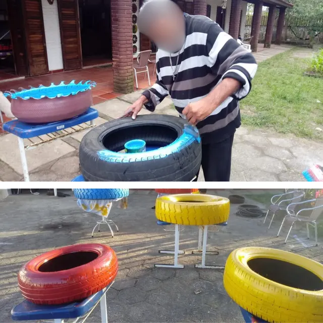 Participante pintando pneu em atividade de reaproveitamento, com identidade preservada